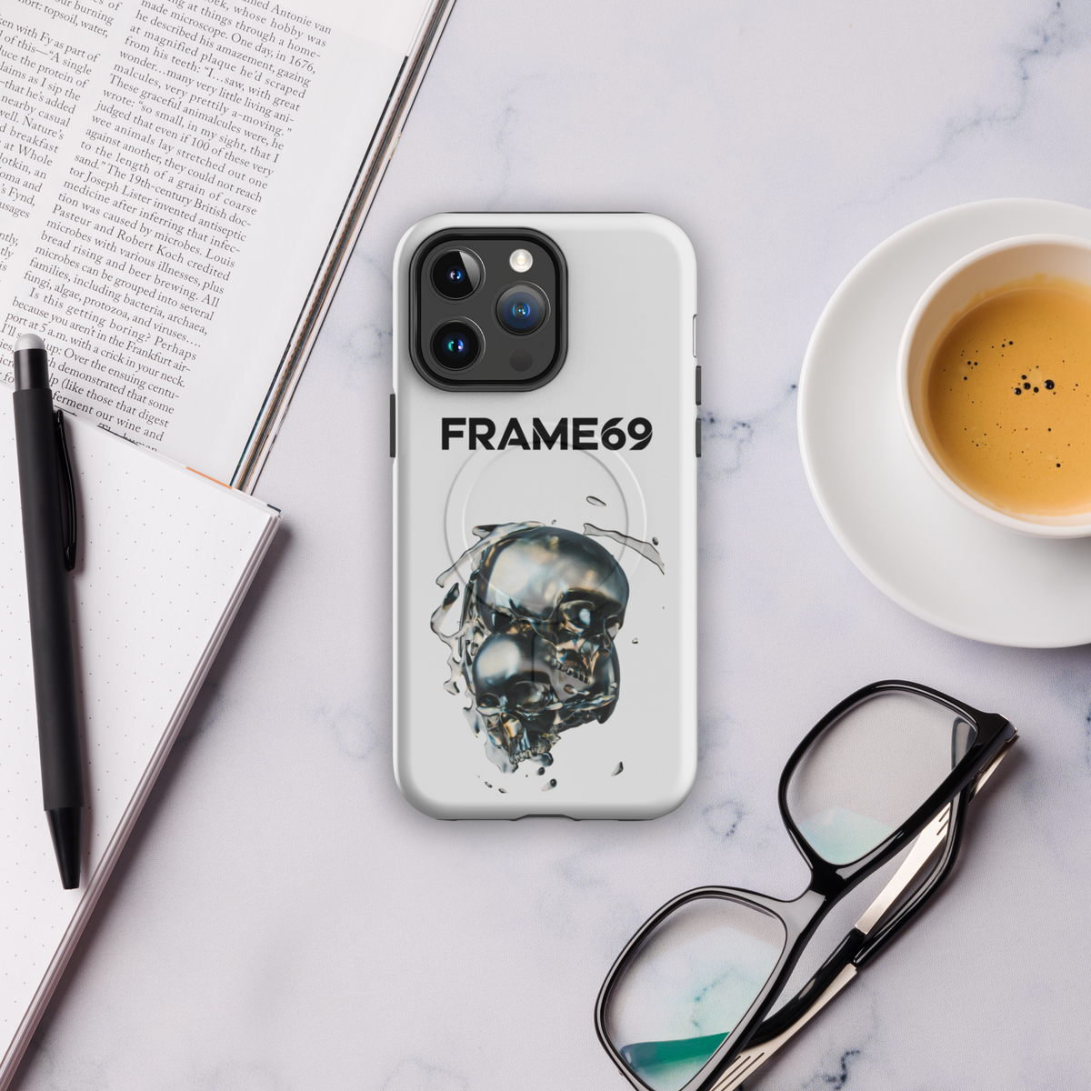 Light gray MagSafe phone case with skull art and camera cutouts, FRAME69 logo