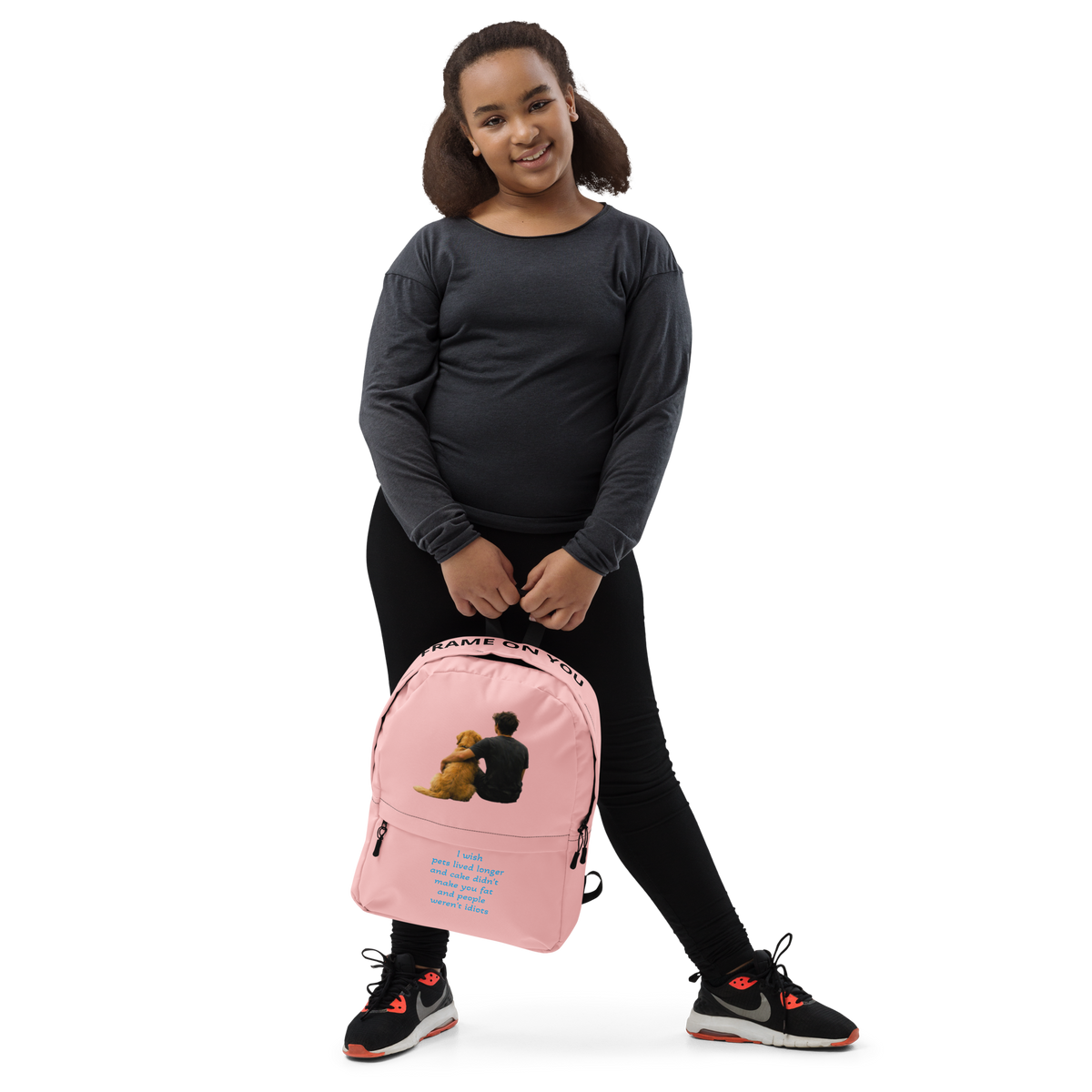 Pink everyday backpack worn by model; front teddy bear graphic and zipper pockets