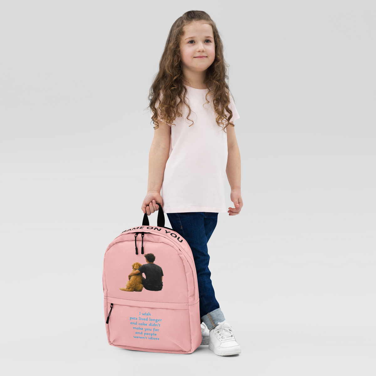 Pink everyday backpack on child’s back with front teddy bear graphic and zippers