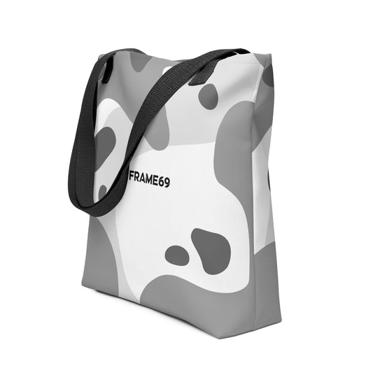 White graphic tote bag with black handles, abstract cow print, FRAME69 logo.