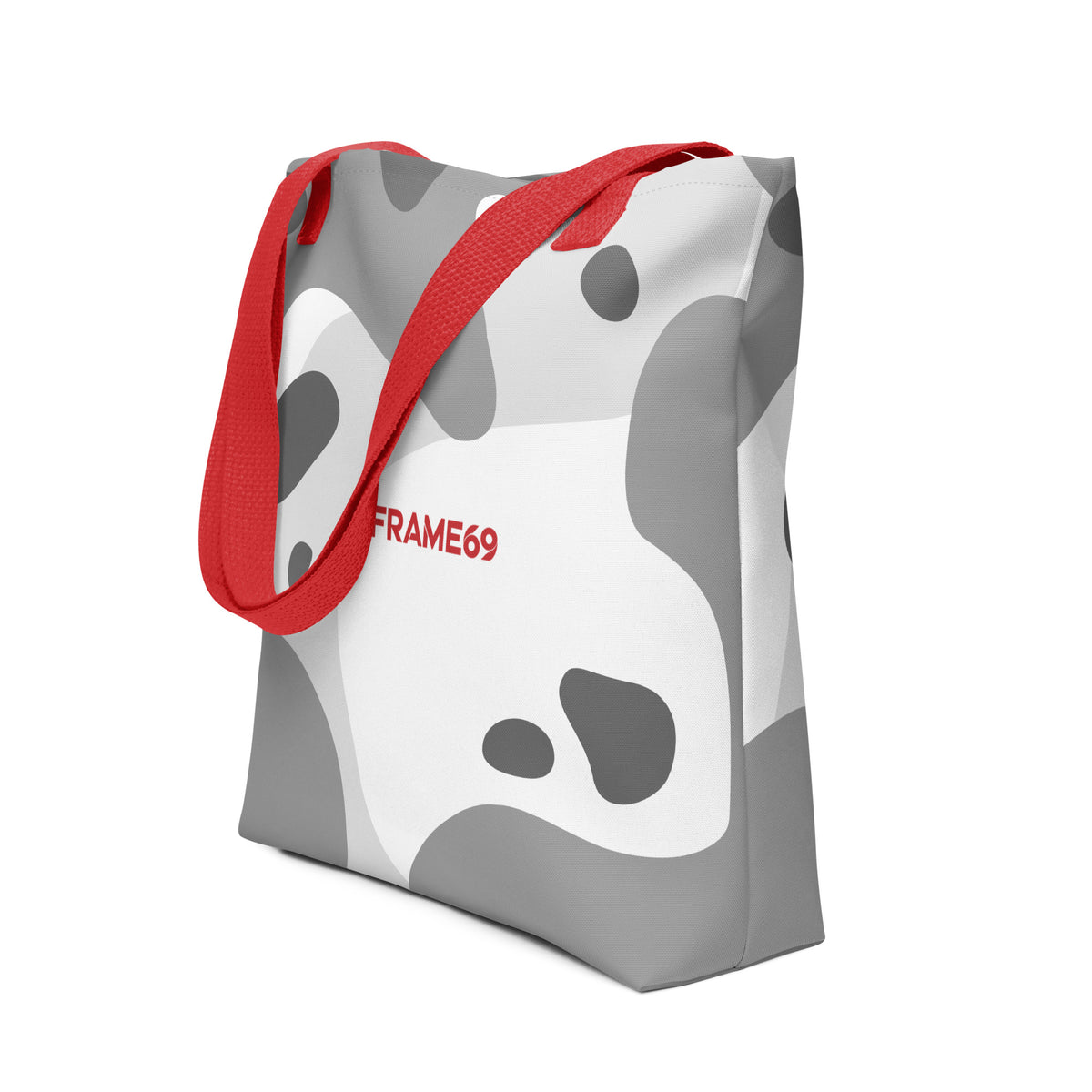 White graphic tote bag with red handles, abstract cow print, FRAME69 logo.
