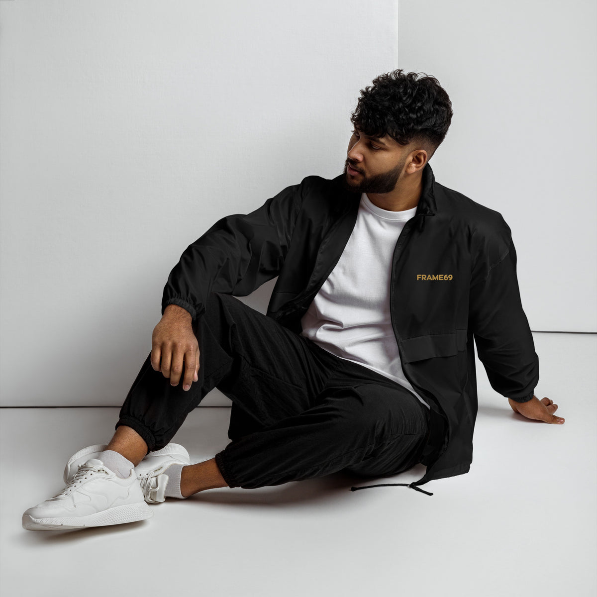 Black windbreaker jacket with chest logo, snap pockets, relaxed fit