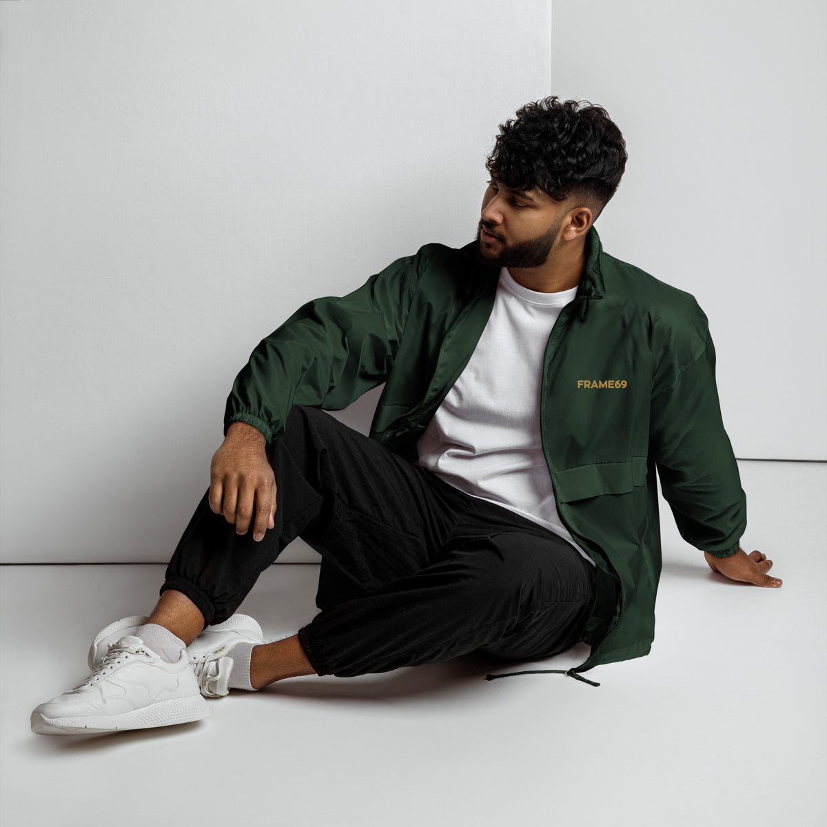 Forest green windbreaker with hood, full-zip front, and FRAME69 logo on chest