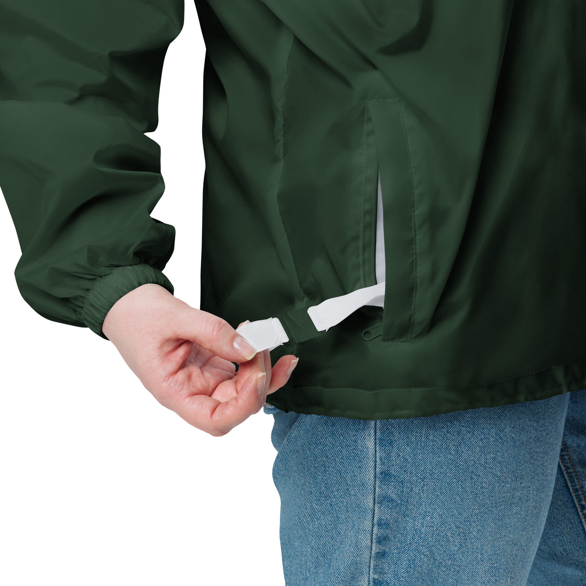 Forest green windbreaker jacket close-up at hem with attached tag and snap detail